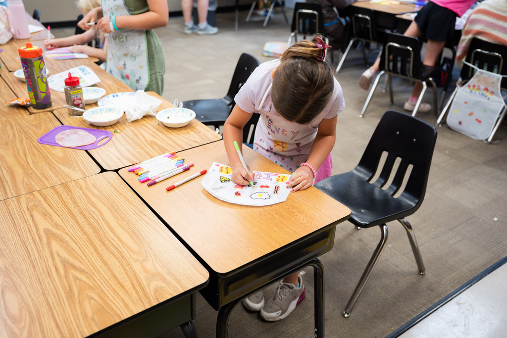 students in chef outfits and hats taking a cooking class