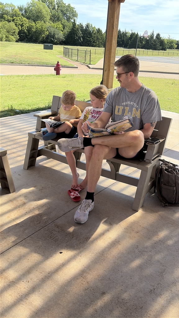 Students/parents/teachers reading at Books & Buddies summer event.