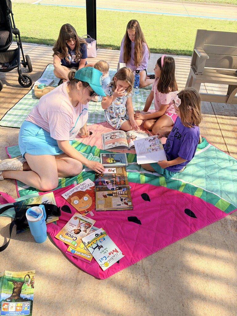 Students/parents/teachers reading at Books & Buddies summer event.