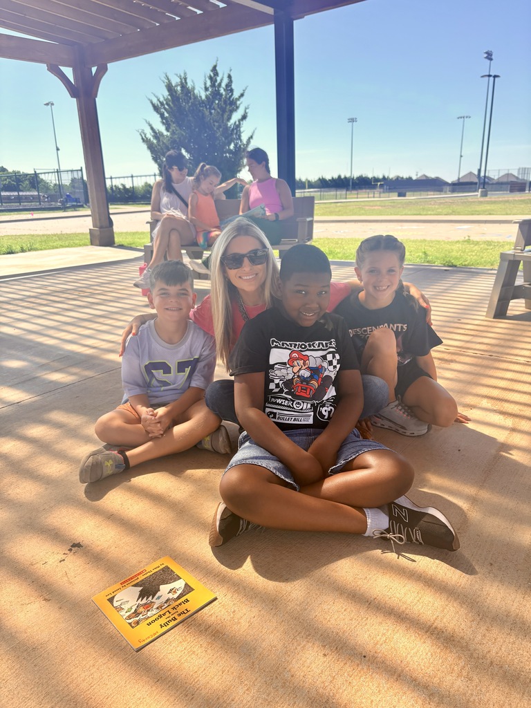 Students/parents/teachers reading at Books & Buddies summer event.