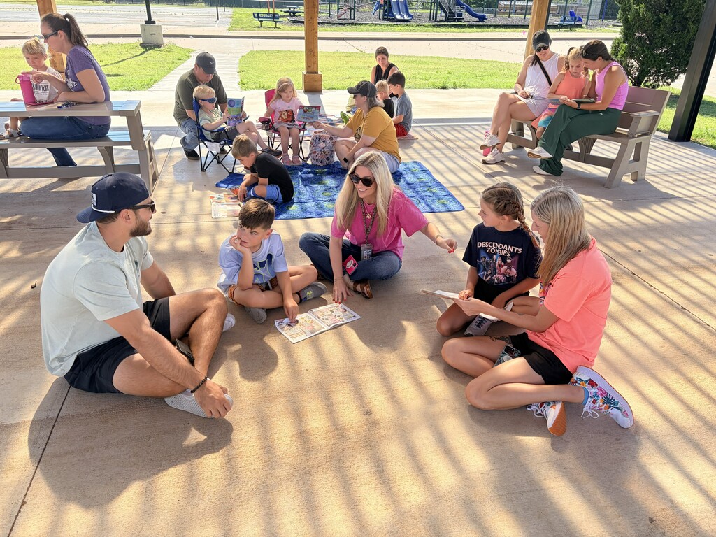 Students/parents/teachers reading at Books & Buddies summer event.