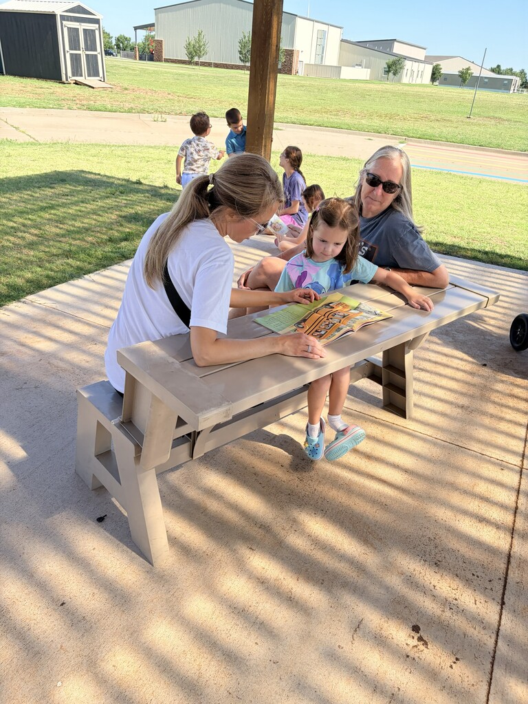 Students/parents/teachers reading at Books & Buddies summer event.