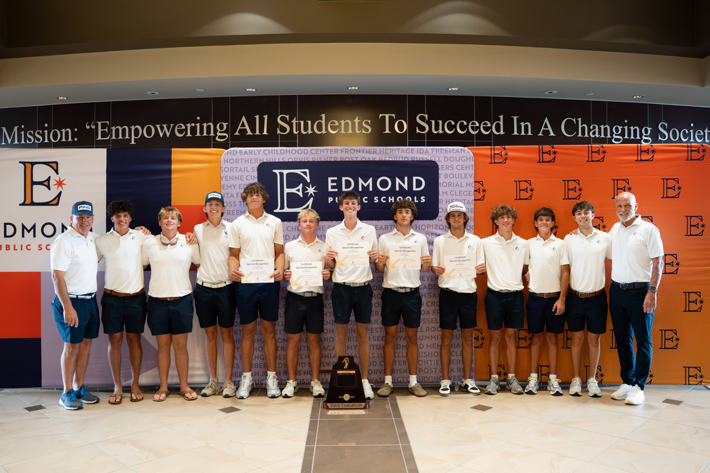 boys golf team posing with their trophy