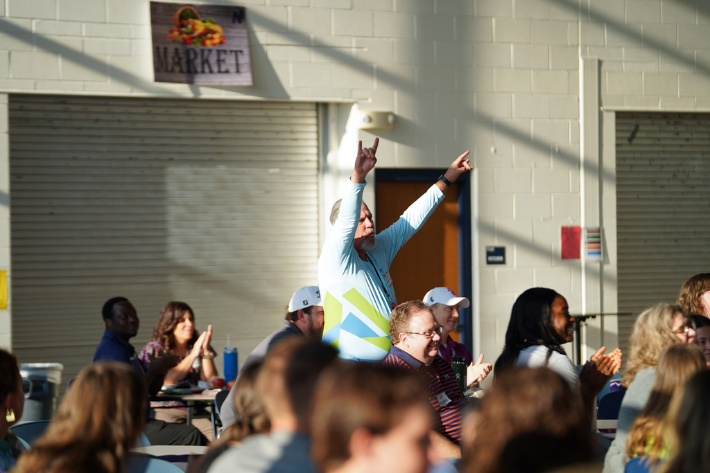 man standing up and cheering