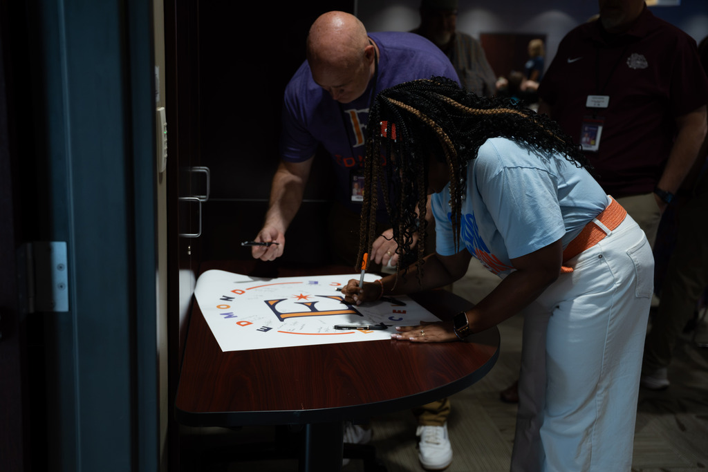 people signing a piece of paper