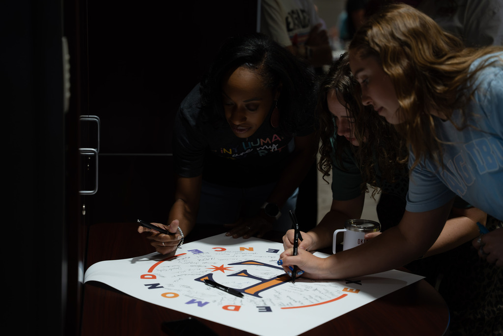 people signing a piece of paper