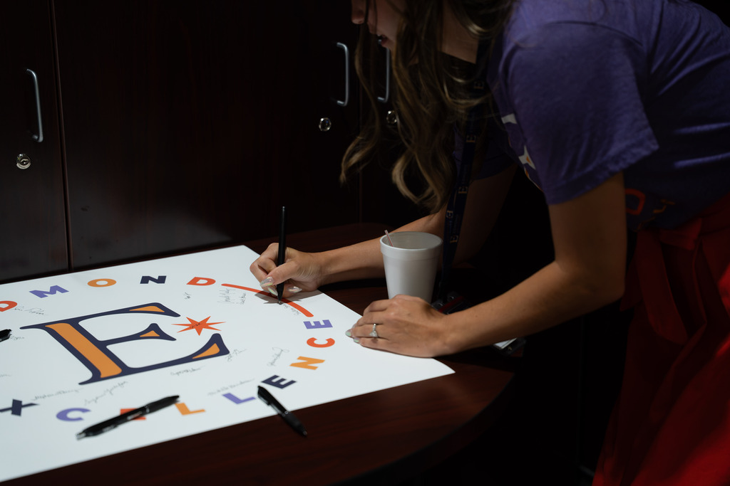 people signing a piece of paper