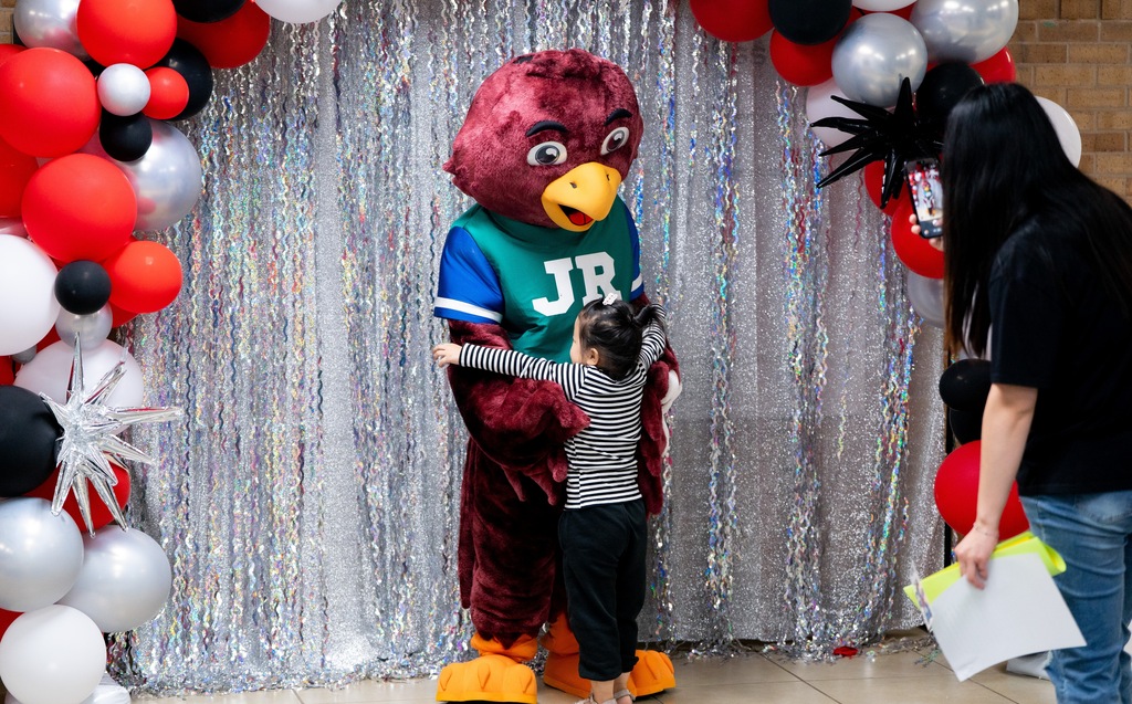 student hugging a mascot