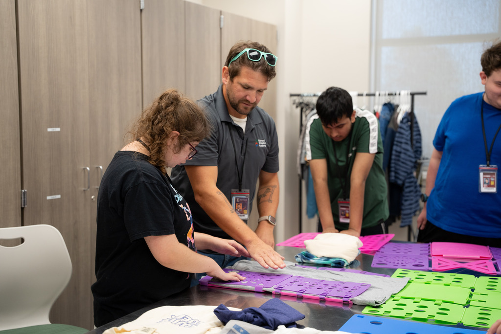teacher helping intern fold clothes