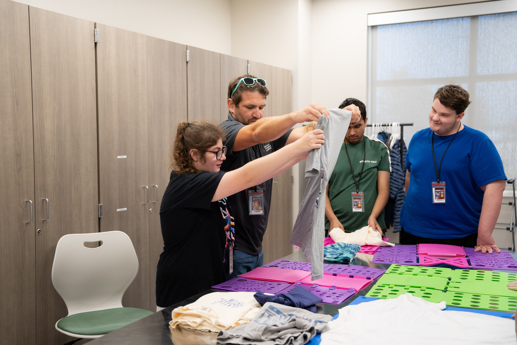 teacher helping intern fold clothes