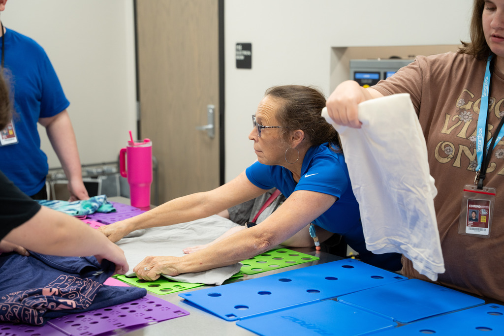 teacher helping intern fold clothes