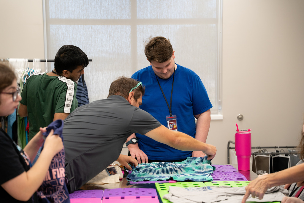 teacher helping intern fold clothes