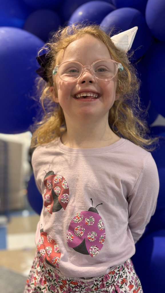 student in front of blue balloons 