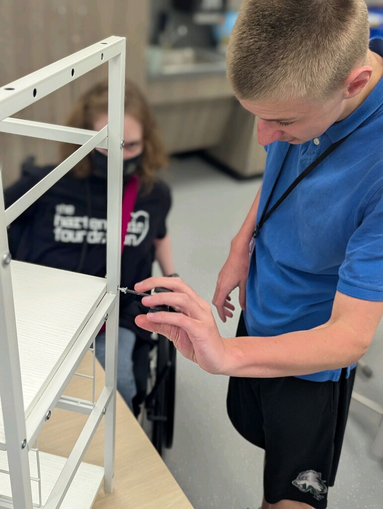 An intern building a storage shelf