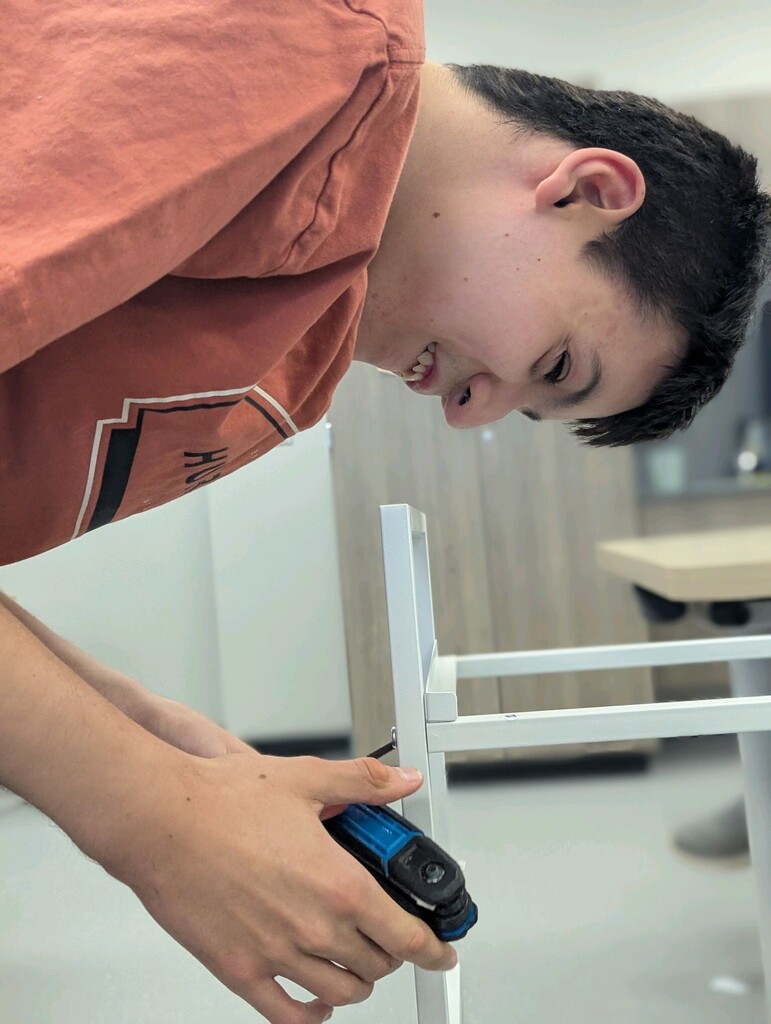 An intern building a storage shelf