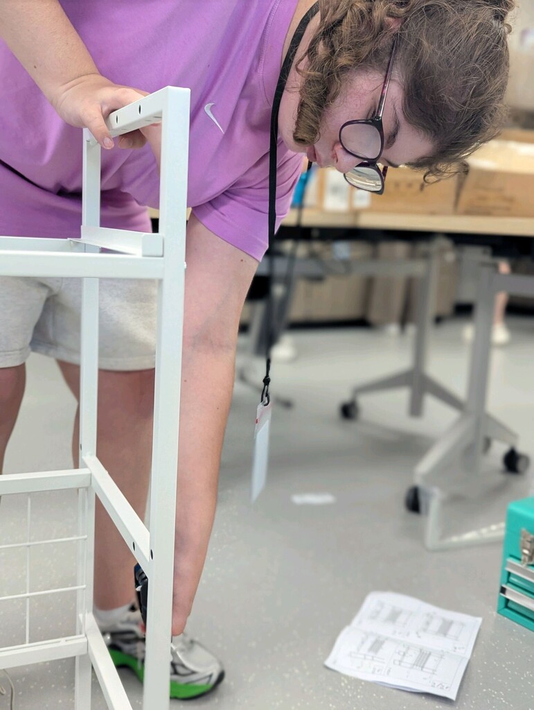 An intern building a storage shelf