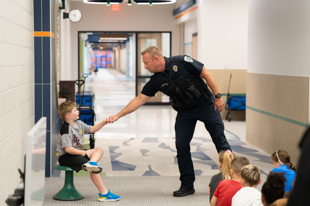 police officer giving a student a fist bump