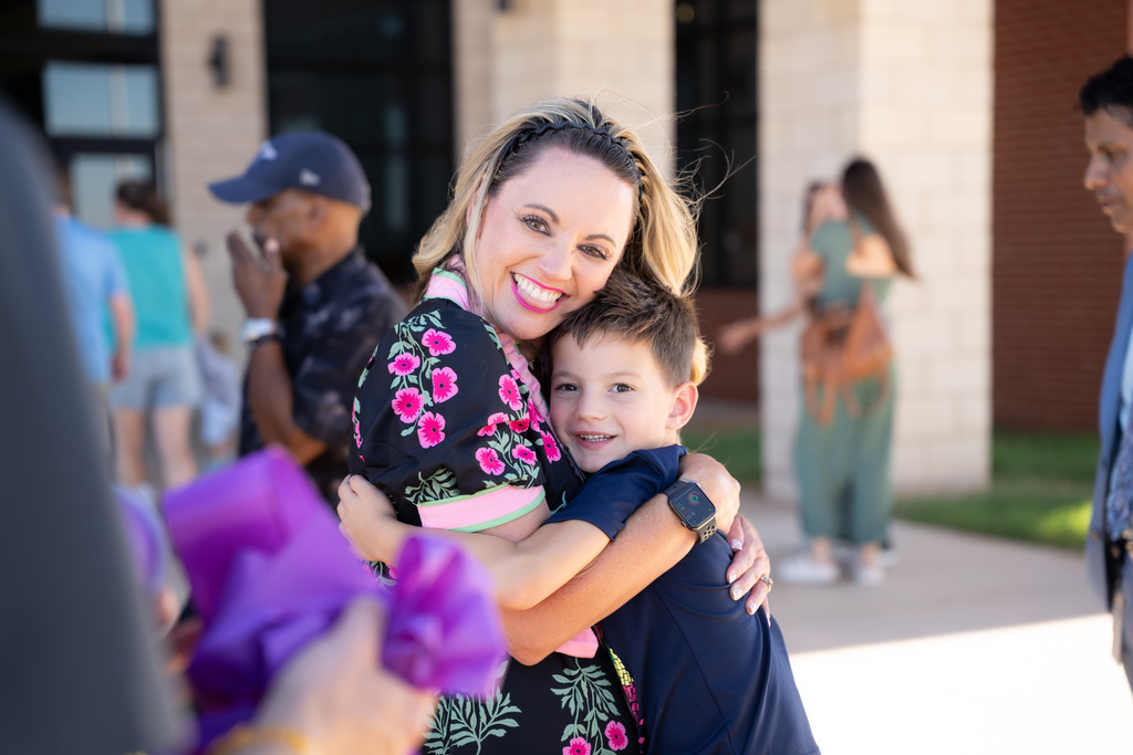 principal and student hugging