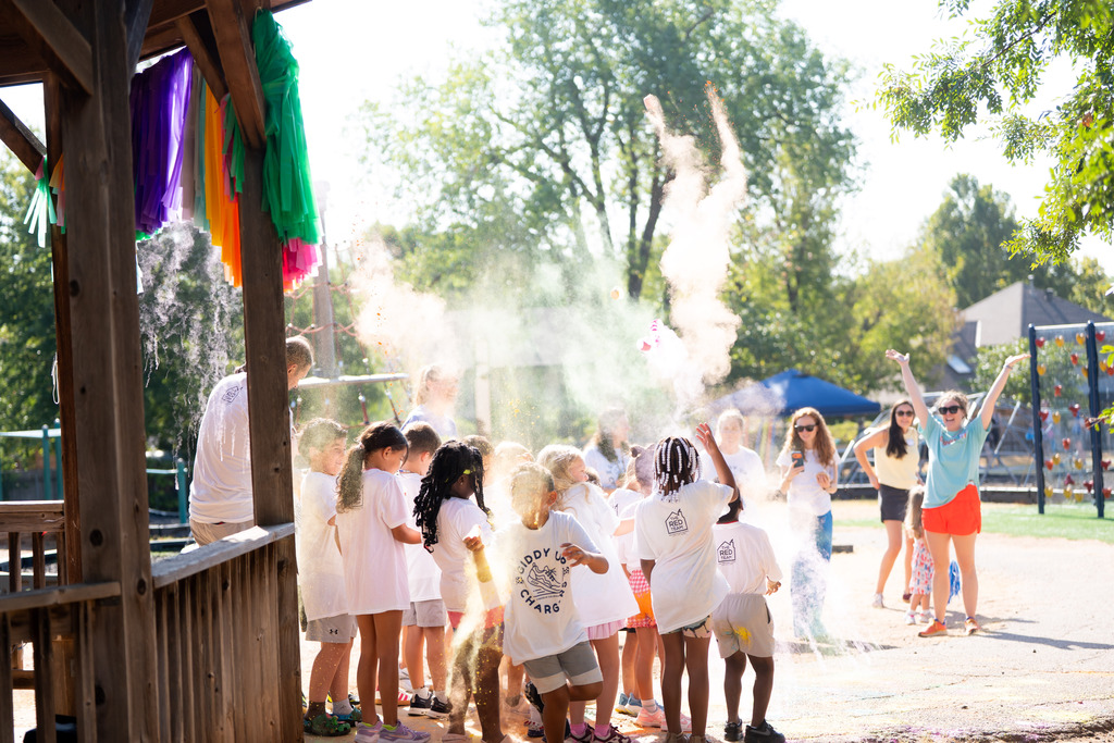students throwing color powder before running in a color run