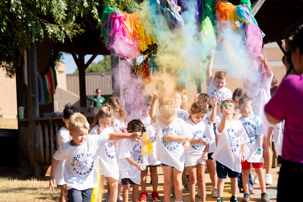 students throwing color powder before running in a color run