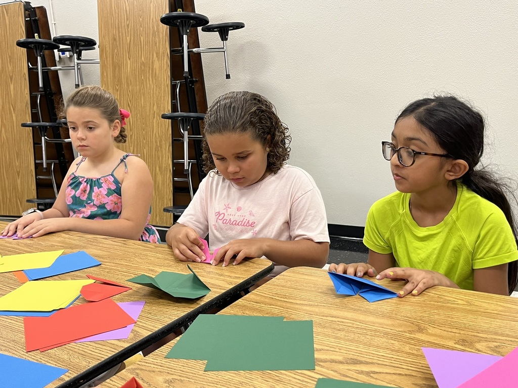 Students folding origami at the summer reading party.