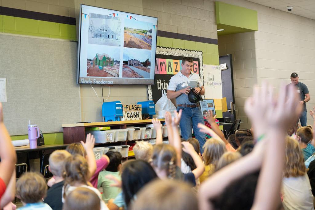 adult talking at the front of the room about their job to students