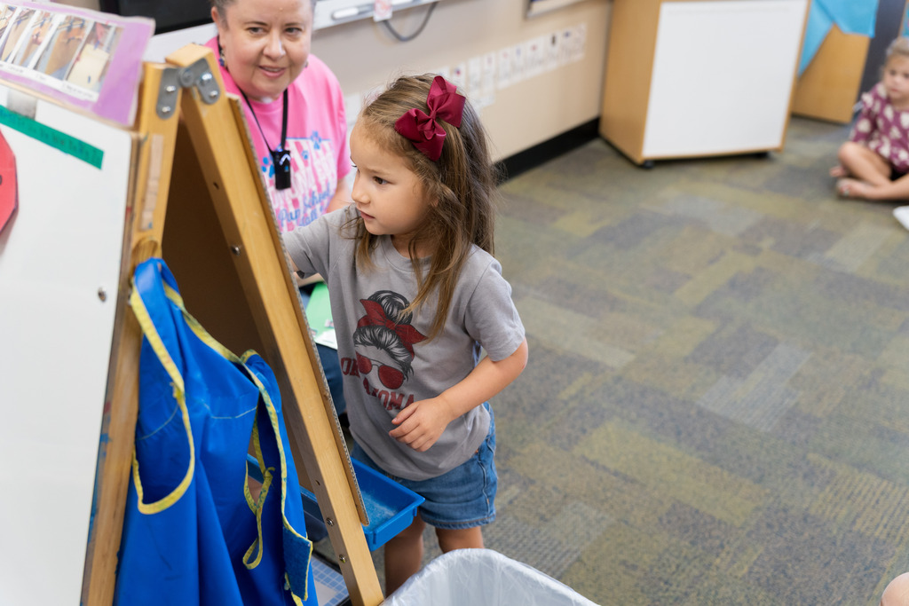 student putting her magnet on a white board