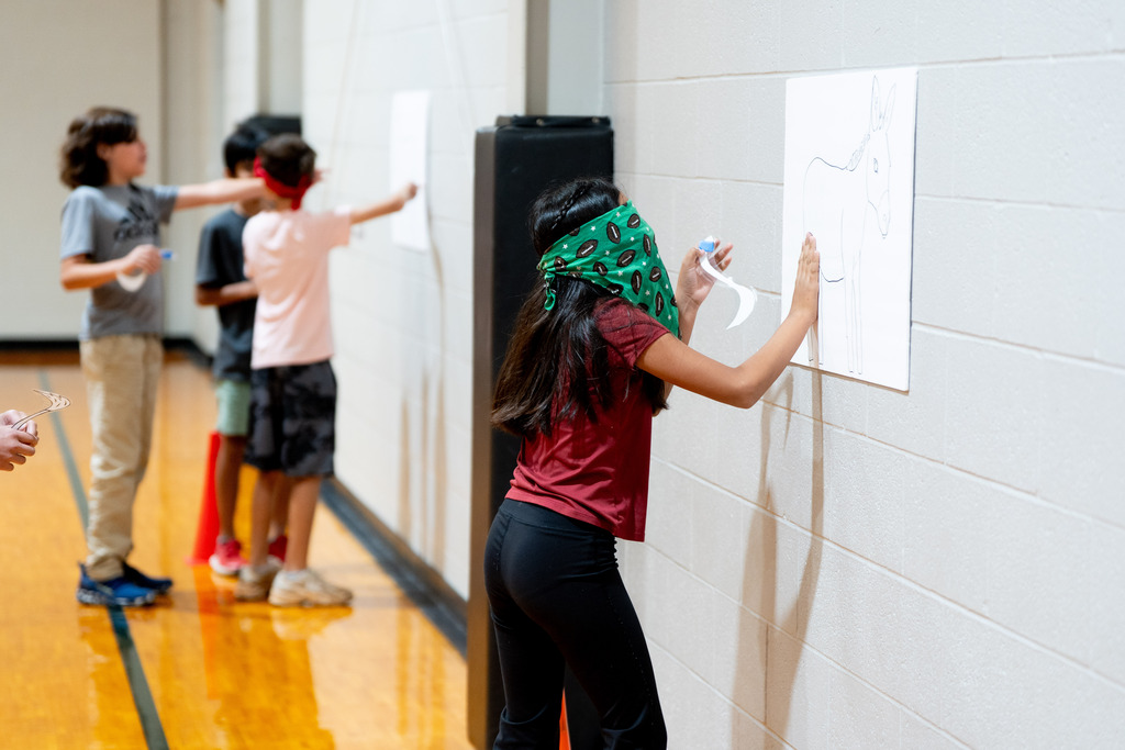 student playing pin the tail on the donkey 