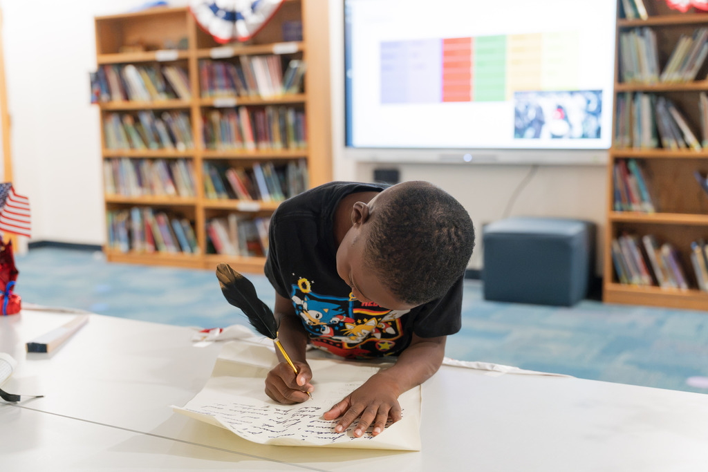 student signing a replica constitution