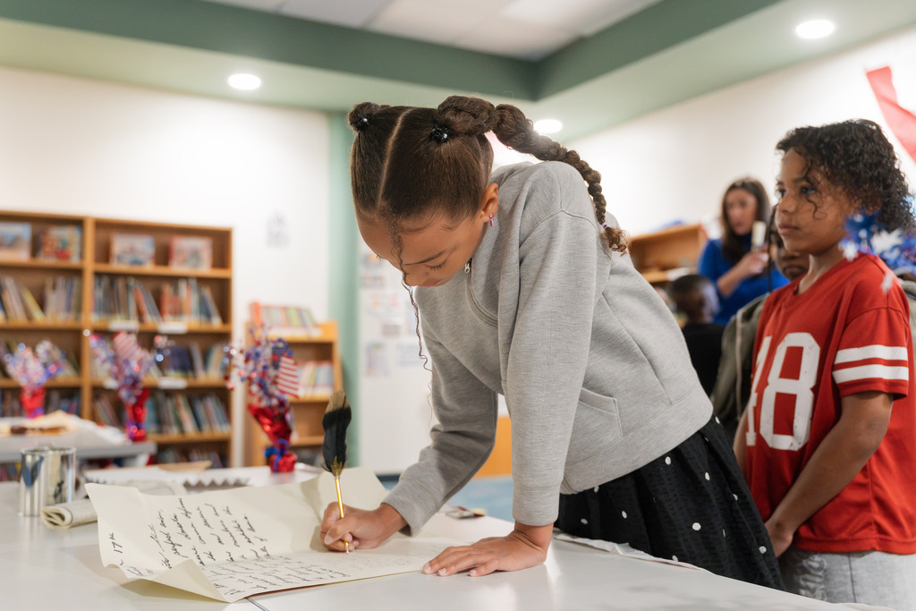 student signing a replica constitution
