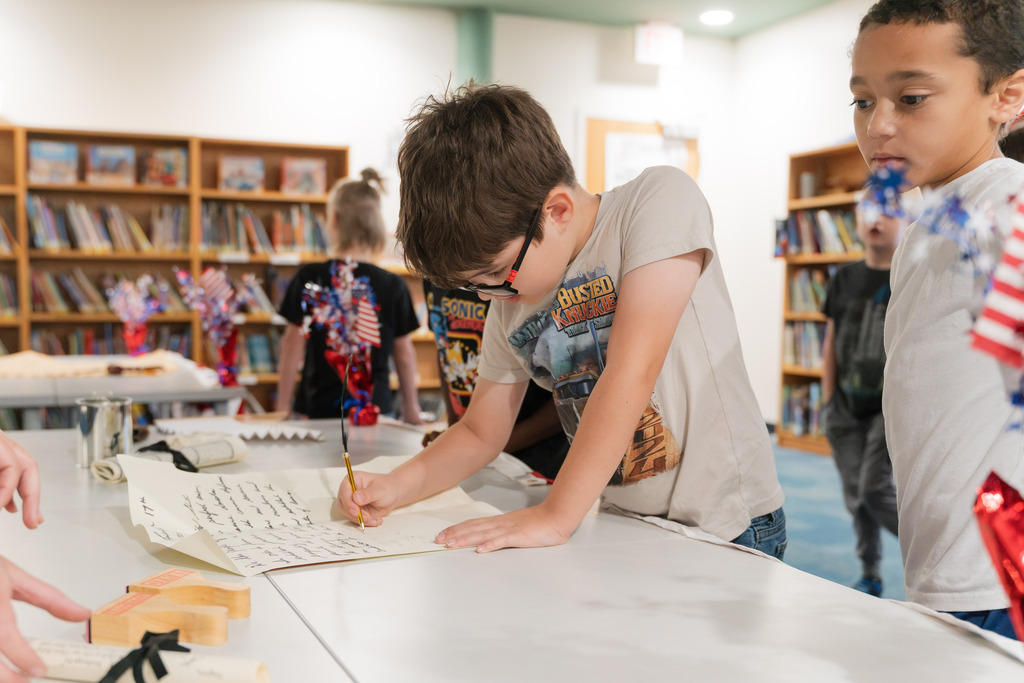 student signing a replica constitution