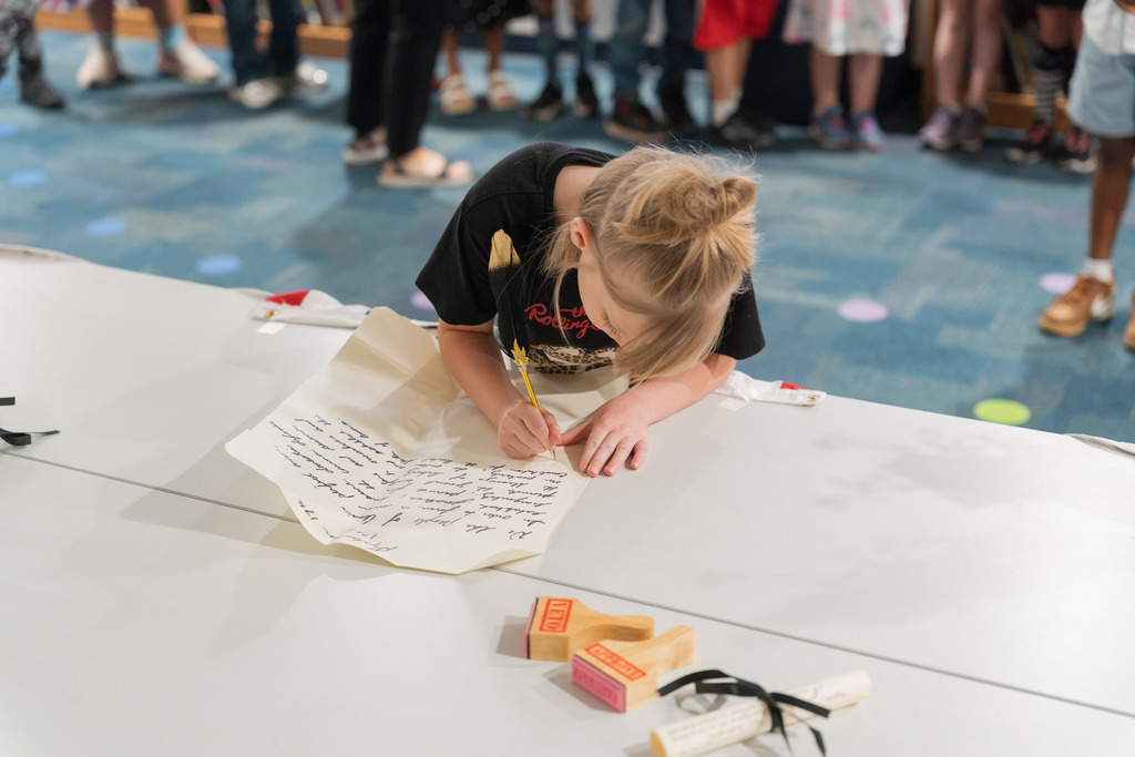 student signing a replica constitution