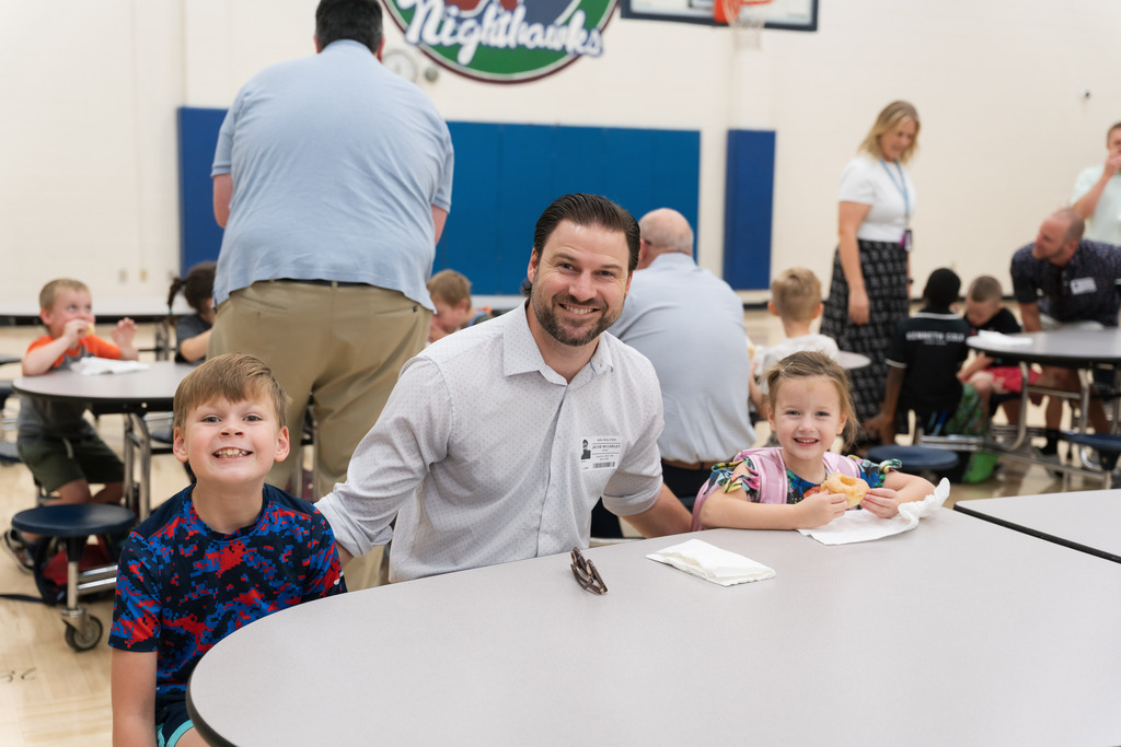 students smiling with their dad