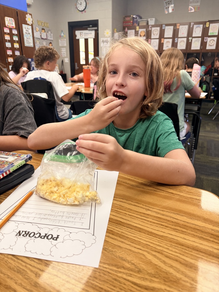 kid eating popcorn and doing work