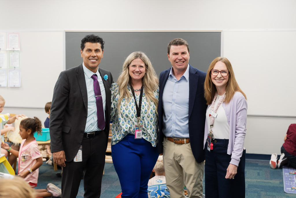 state superintendent posing with superintendent, principal and teacher