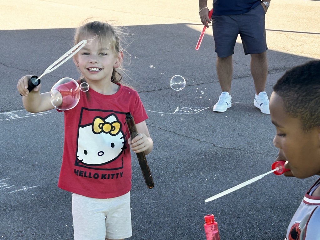 Kindergarten students blowing bubbles.