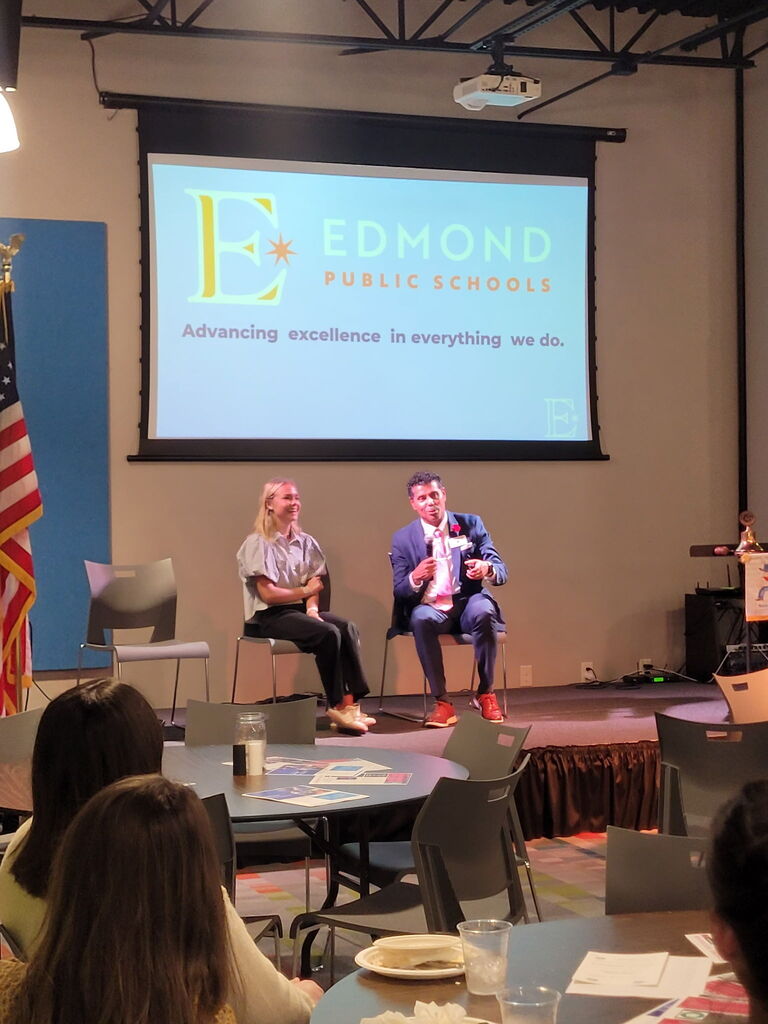 students talking on stage with superintendent
