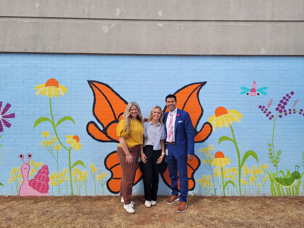 student posing with superintendent and principal