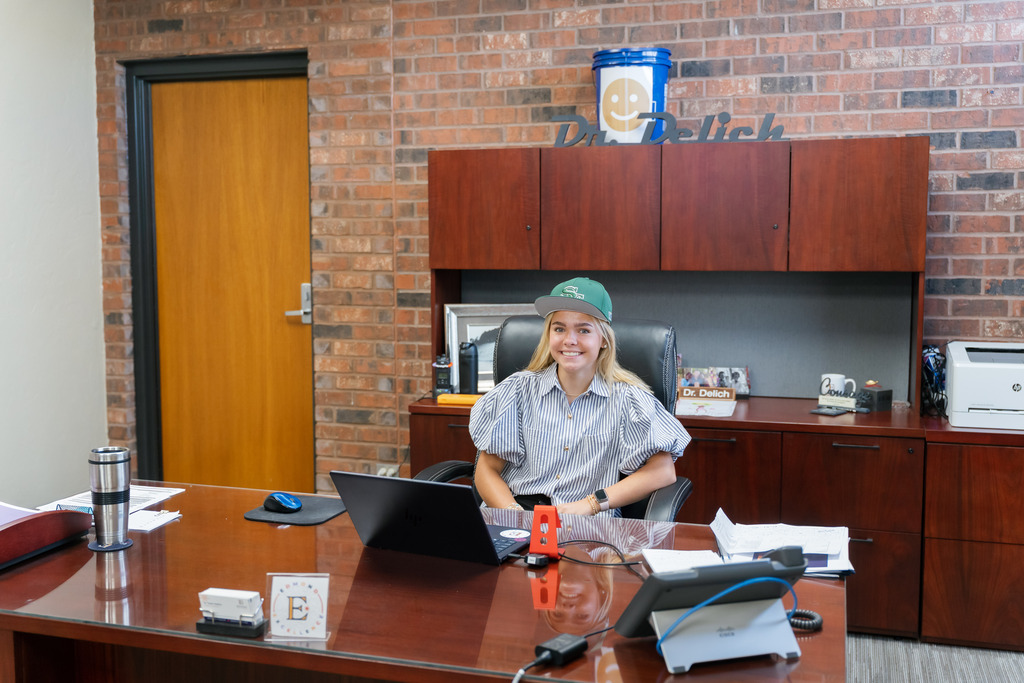 student posing at superintendent's desk