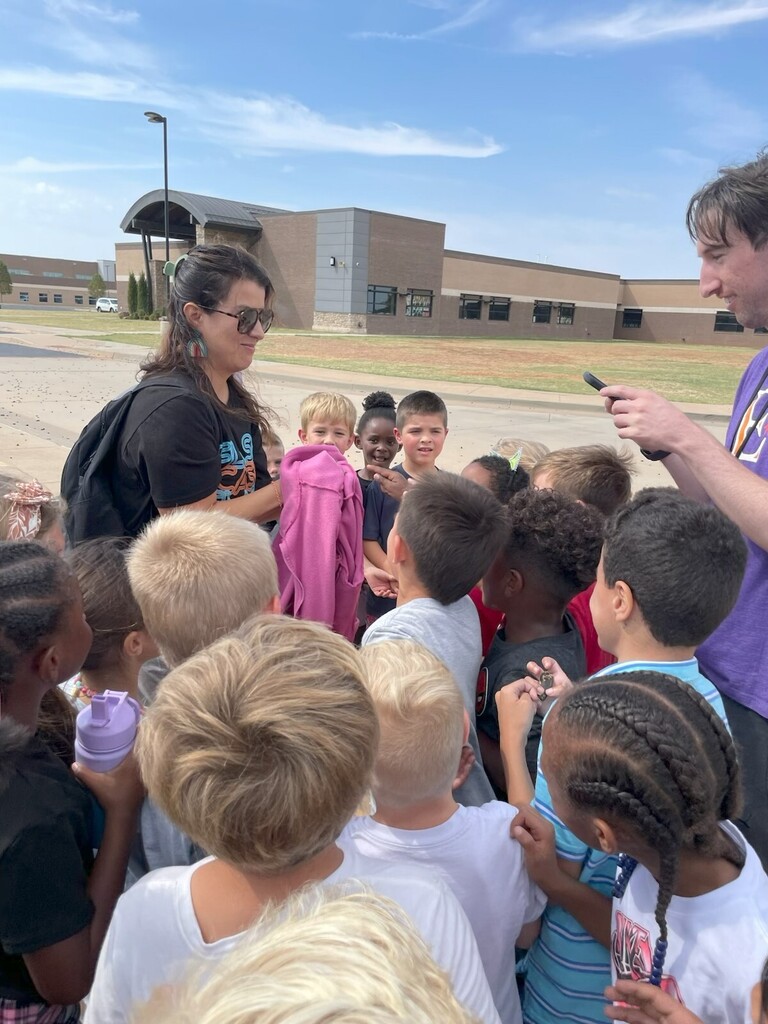 teacher rescuing frog during recess on playground