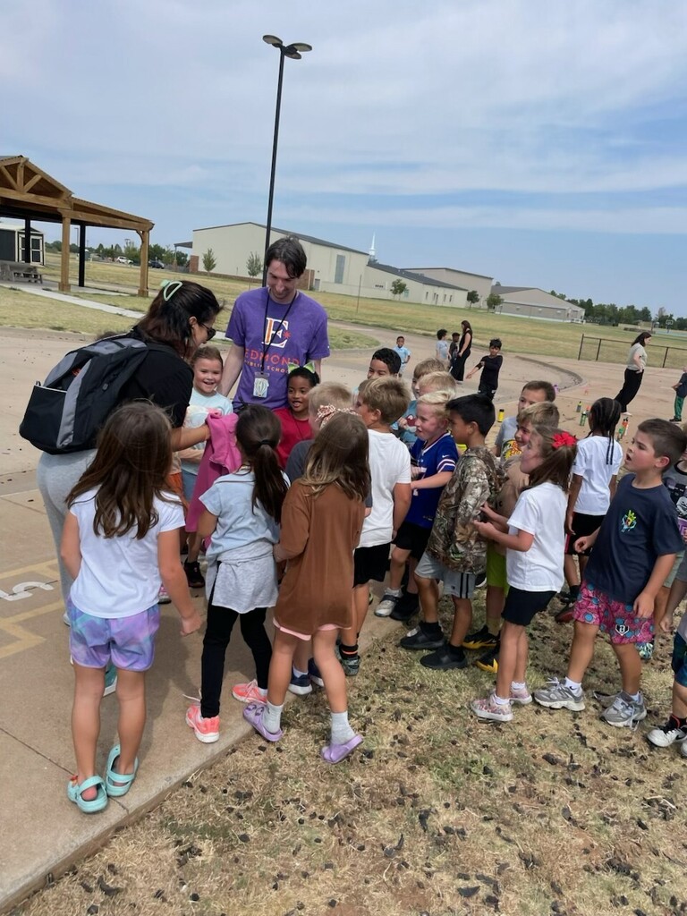 teacher rescuing frog during recess on playground