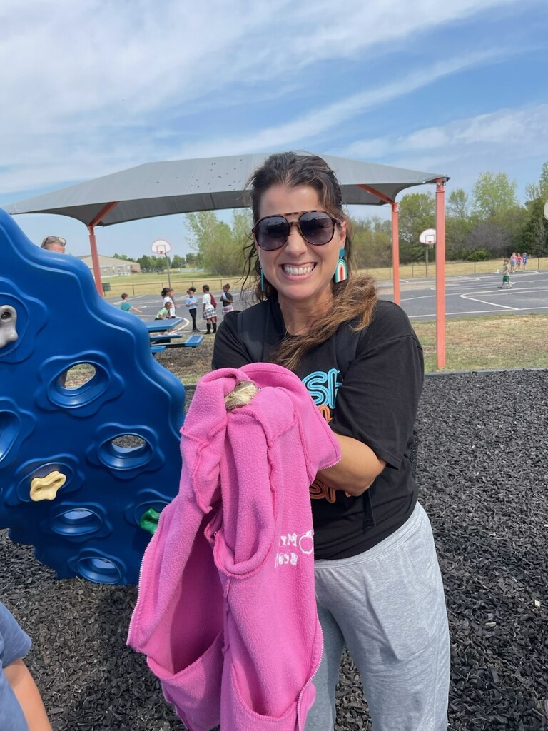 teacher rescuing frog during recess on playground