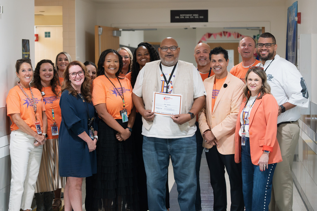 core value award recipient standing with administrators and holding their award