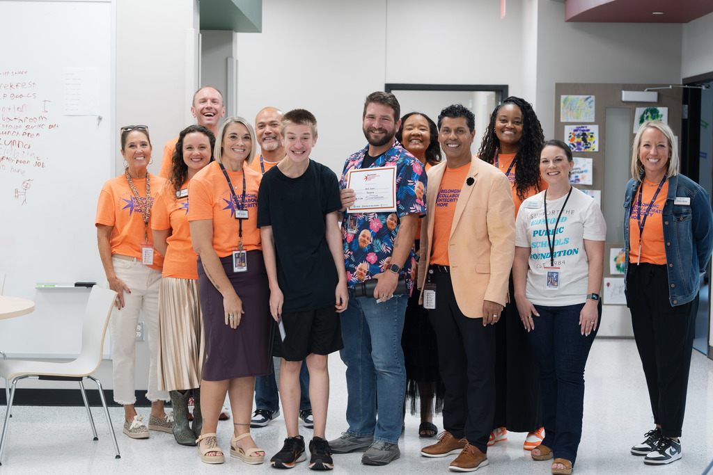 core value award recipient standing with administrators and holding their award