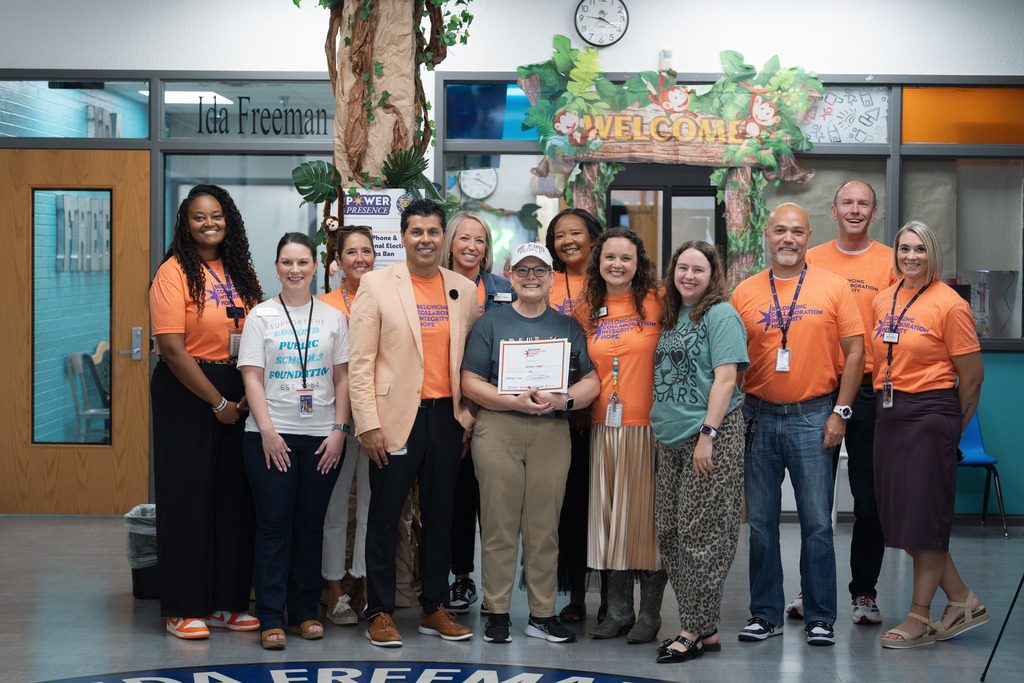 core value award recipient standing with administrators and holding their award