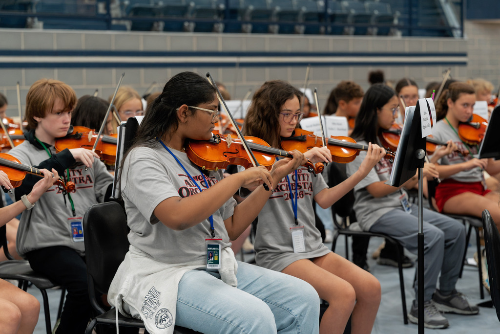 middle school student playing instrument in large band room
