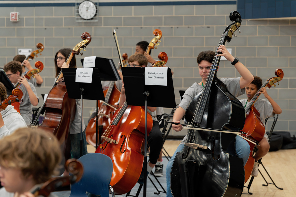middle school student playing instrument in large band room