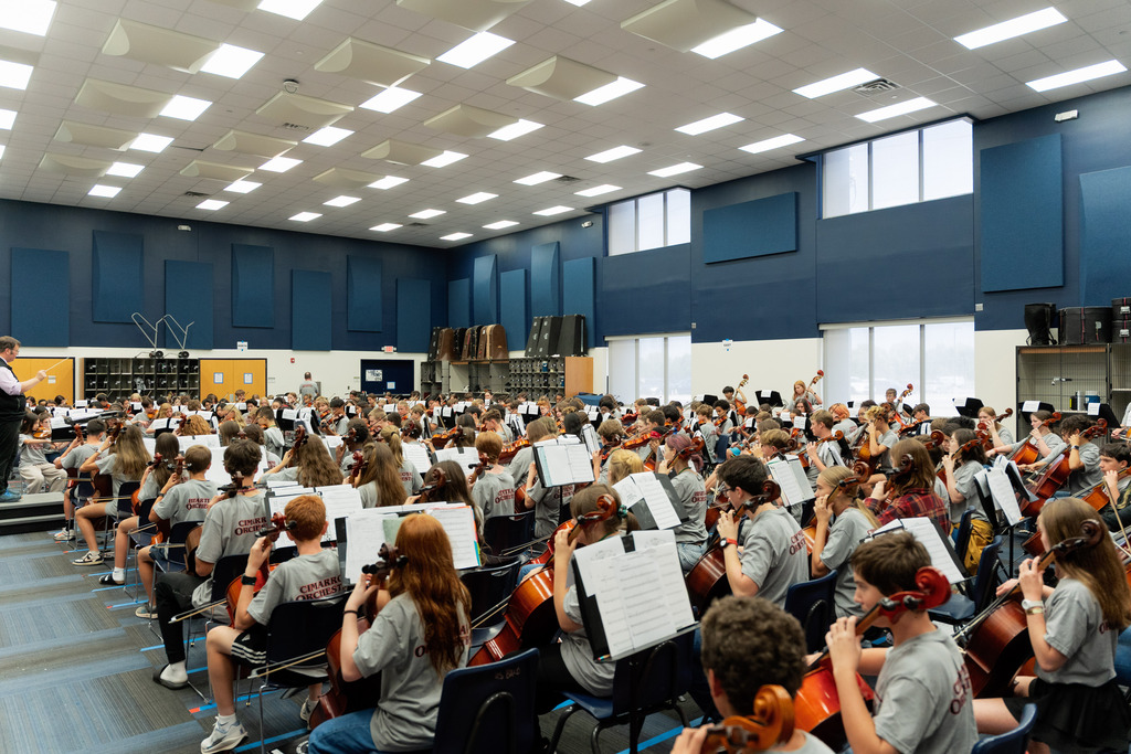middle school student playing instrument in large band room