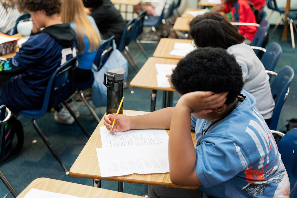 student writing on paper