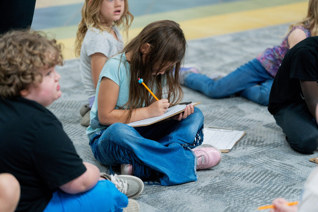 student writing on a clipboard